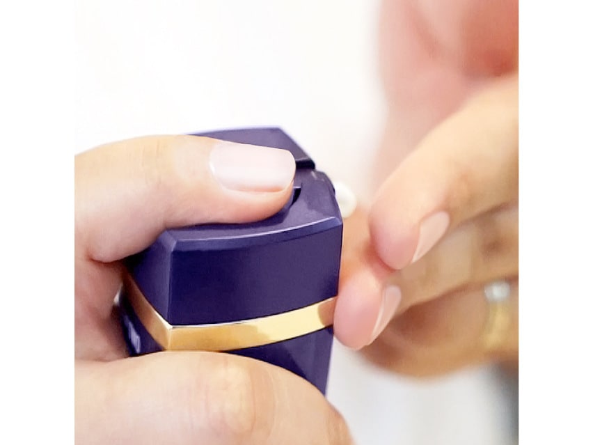 A woman putting DefenAge 8-in-1 BioSerum on her hand to apply it